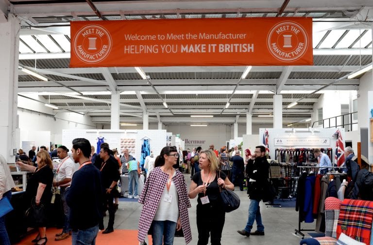 Visitors in the aisles under the Meet the Manufacturer banner