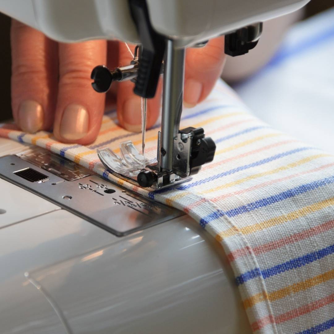 Close-up of fabric being sewn on a sewing machine